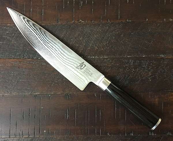 Shun Classic 8-inch chef knife on wooden side table.